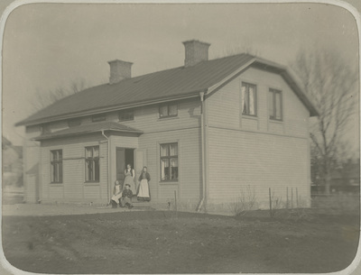 Gruppbild framför hus i Nyköping, 1890-tal