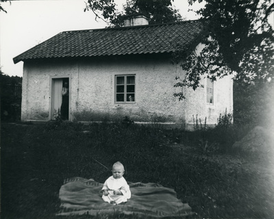 Torpet Gåsmyran med Hilda och Erik Anderssons dotter sittande framför. Ruth Andersson.