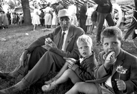 En äldre man och två barn äter varmkorv, 1961