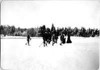 Sällskap med stavar på isen vintertid, tidigt 1900-tal