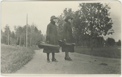 Två kvinnor med fioler på landsväg