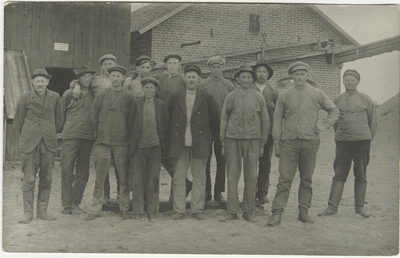Gruppfoto på arbetare framför byggnad