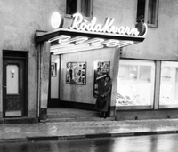 En kvinna står och väntar utanför biografen Röda Kvarn i Nyköping