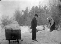 Kvinna och man samlar snö och is på kälke, till isdösen?