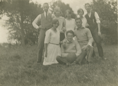 Gruppfoto på unga män och kvinnor på en gräsmatta