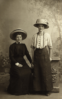 Porträttfoto av två unga kvinnor i stora hattar