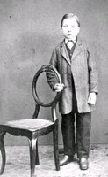 En okänd poke står vid en stol