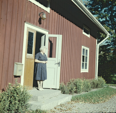 En kvinna i dörren till flygeln vid Västra Vingåkers prästgård