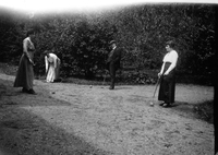 Tre damer och en man spelar krocket