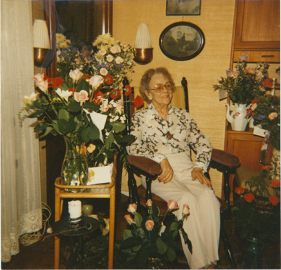 En kvinna sitter omgiven av blommor