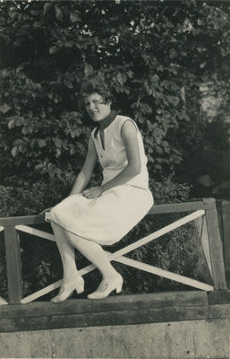 Kvinna sitter på ett räcke