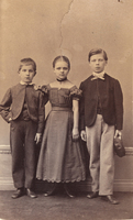 Två pojkar och en flicka, finklädda inför fotograferingen, 1860-tal