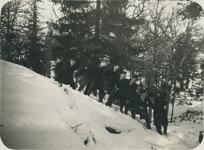 Unga män på ett snötäckt berg i skogen