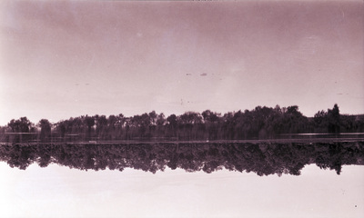 Landskapsbild med en sjö och skog