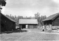 Uthus, några träföremål står utanför ett av husen