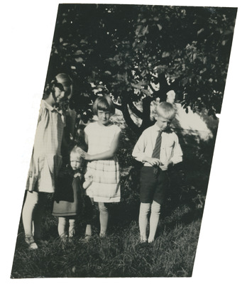 Porträtt på fyra barn i en trädgård, 1920-talet