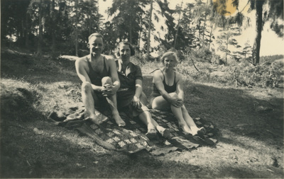 En man, Karin och Gertrud Höglund på en filt