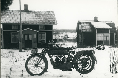 Lundaborg på Överåsbacken. Husqvarna motorcykel ägd av byggmästare Hilmer Karlsson. Mellan husen skymtar Zaberg.