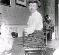 Kvinna framför trattgrammofon och skivor