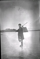 Fiskare med fiskekorg på isen