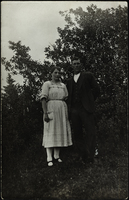 En man och en kvinna står bredvid varandra på en gräsmatta