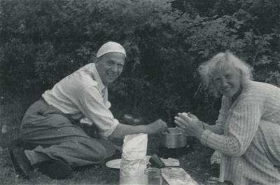 Gertrud Höglund och en man lagar mat på spritkök
