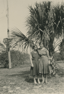 Två kvinnor framför en palm