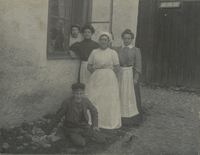 Fem kvinnor och en pojke fotade framför en husfasad, sannolikt vid Benninge folkhögskola