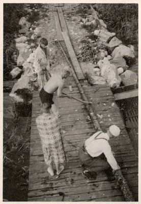 Elever och lärare från Solbacka Läroverk bearbetar ett rör vid sjön, 1933